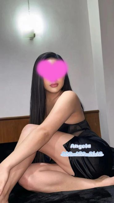 Woman with long hair sitting in black outfit.