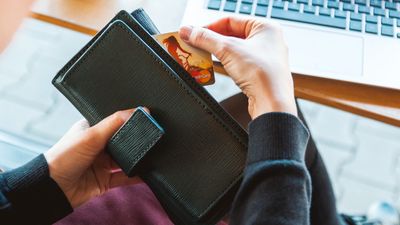 woman taking her credit card out of wallet to pay for something.