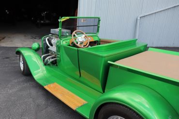 Bright green vintage hot rod truck with wooden accents.