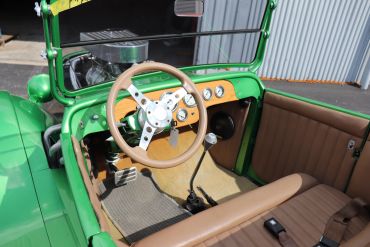 Interior view of a vintage green car with brown seats.