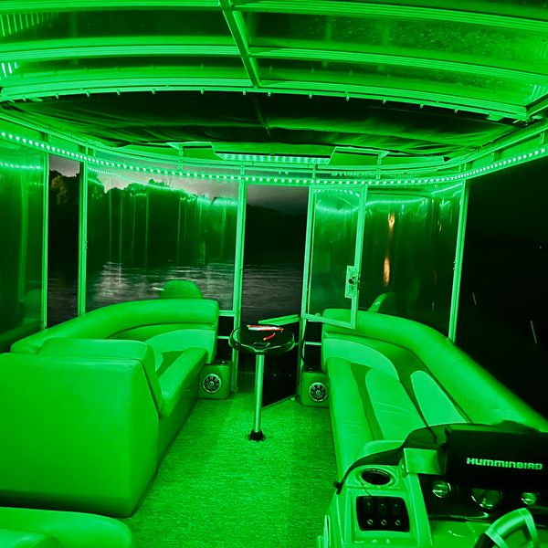 Interior of a boat glowing with green LED lights at night.