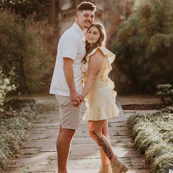 Couple holding hands in a garden path.