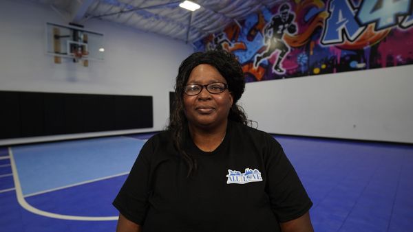 Woman smiling inside a sports court.