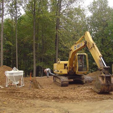 Excavator preparing a site for new home construction and septic system install