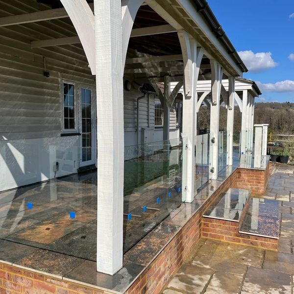 A house deck with granite tiles and glass fences