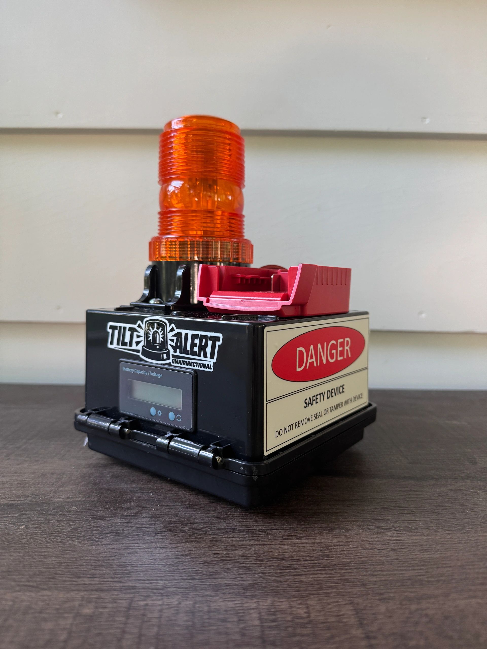 A safety device with an orange alert light and danger warning.
