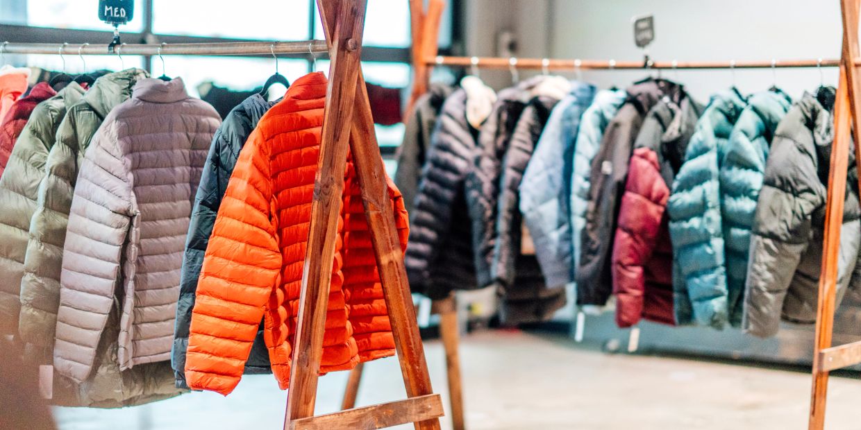 Colorful winter jackets hanging on a rack in a store.