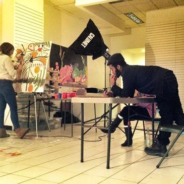 Two people working on art projects in a studio.