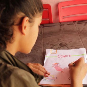 Child drawing a COVID-19 awareness poster.