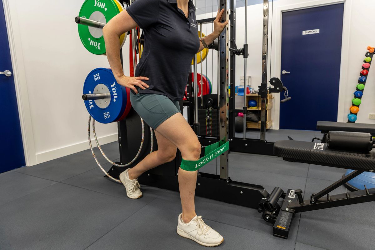 A woman doing a banded strength exercise in the HSP Kedron gym