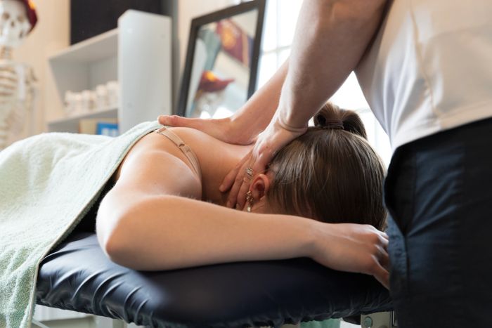 Physio treating a patient's neck and shoulders in a private room