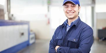 auto technician with safety glasses smiling