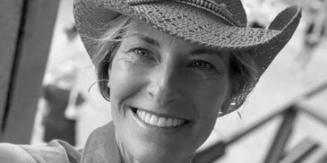 Smiling woman in a hat taking a selfie.