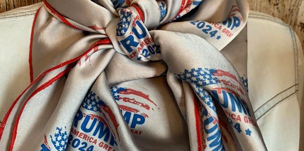 Silky scarf with "Trump 2024 Keep America Great" printed, tied on denim jacket.
