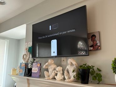 32" TV mounted above fireplace