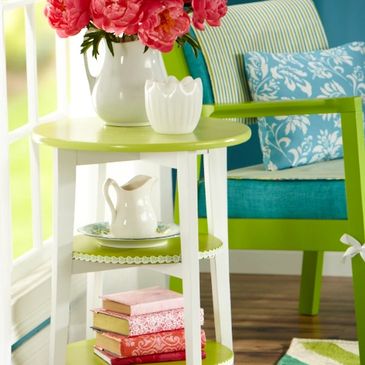 Colorful side table with flowers and books.