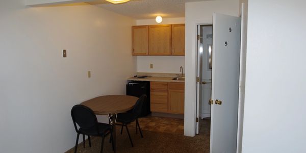 Small kitchenette with table and chairs in a compact room.