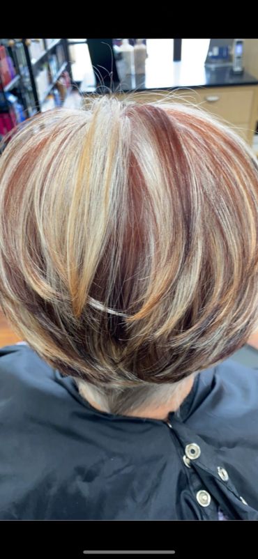 Short layered haircut with blonde and red highlights.