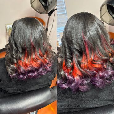 Black hair with vibrant red and purple ombre curls.