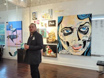 Man in suit observing modern art in a gallery.