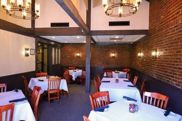 Cozy restaurant interior with brick walls and wooden beams.