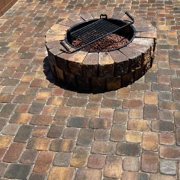 Paver patio with stone firepit in the center.