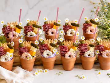 Cute dessert cups decorated with flowers and colorful toppings.