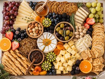 Cheese and fruit charcuterie board with nuts and crackers.