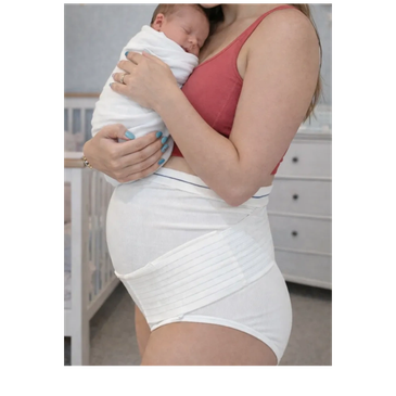 New mother holding her newborn baby while wearing postpartum support underwear.