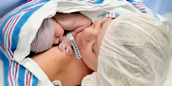 Newborn baby resting on mother's chest immediately after birth in hospital.
