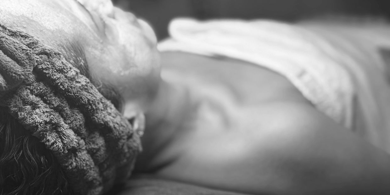Client laying down with treatment mask on her face