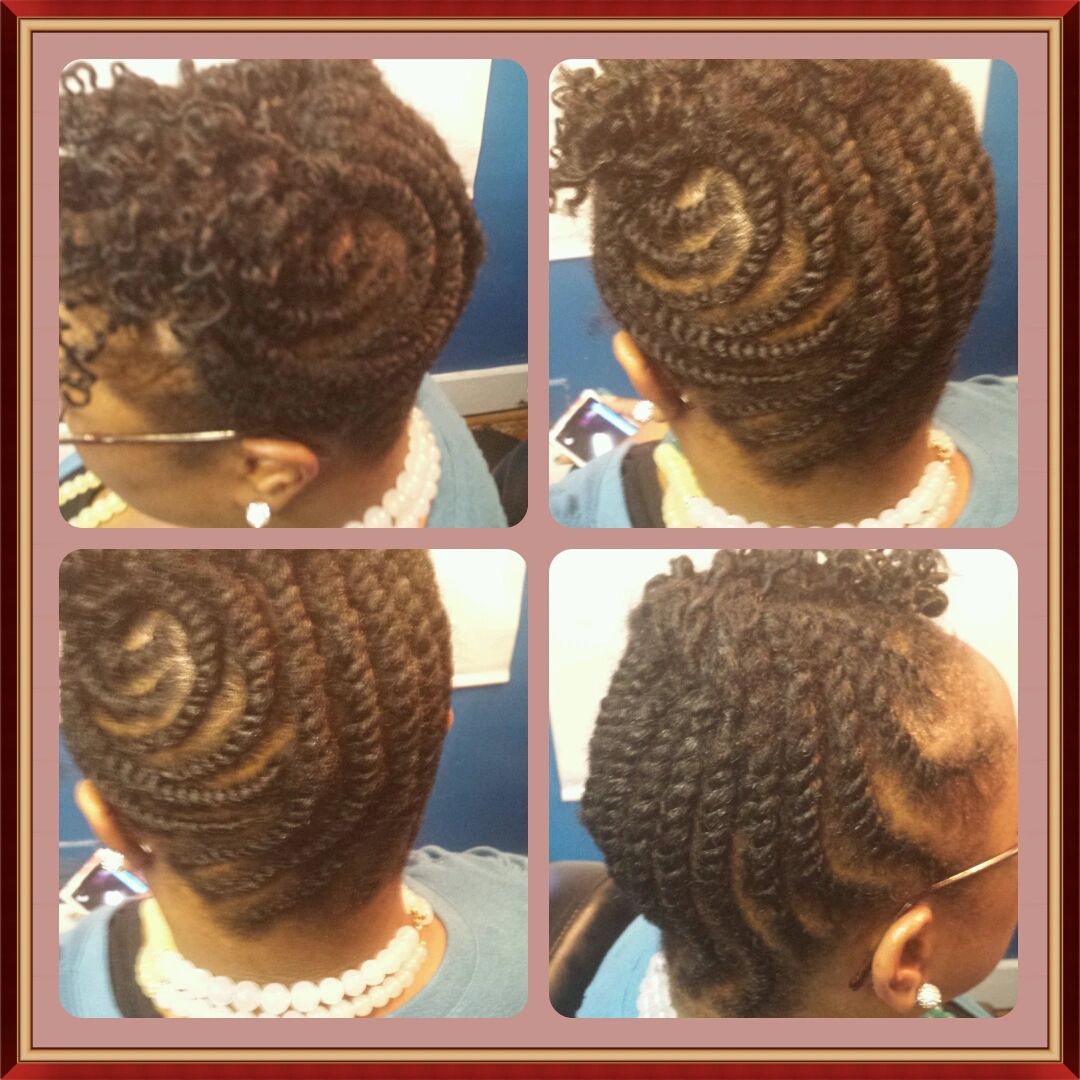 Intricate spiral and twisted cornrow hairstyle on a woman.