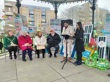 People gathered at an outdoor event with decorations and signs.