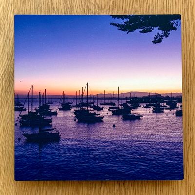Boats anchored at sunset with a serene sky.
