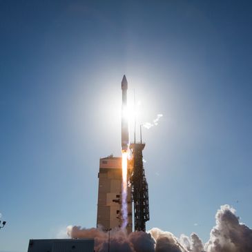 A rocket launches into a clear blue sky.