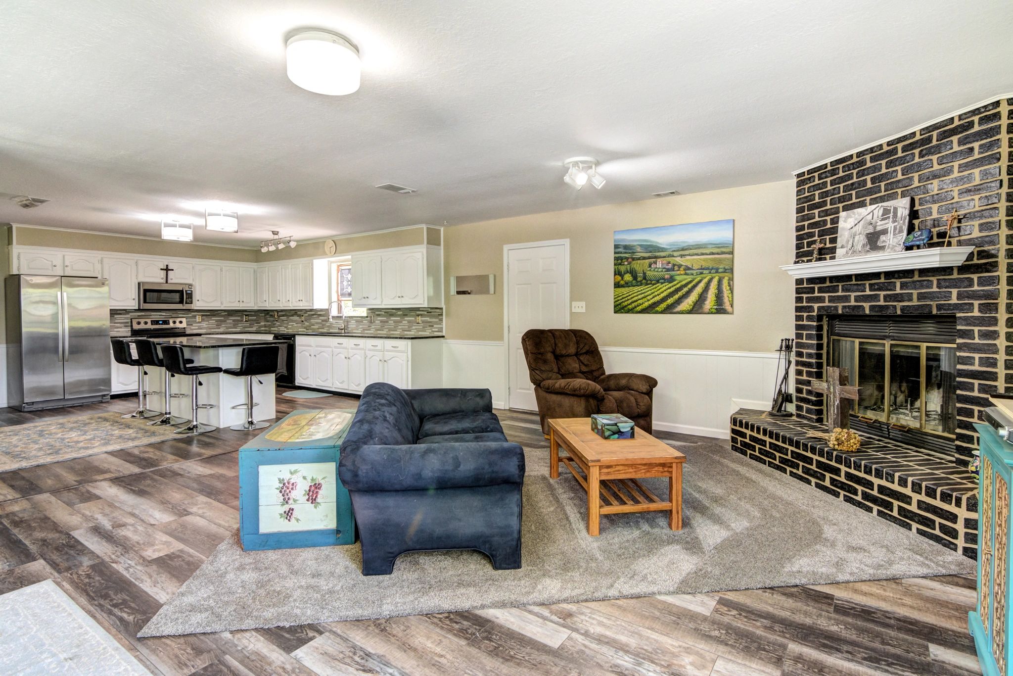 Open living room and kitchen with fireplace and modern appliances.