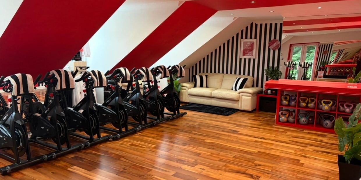 Modern indoor gym with exercise bikes and kettlebells.