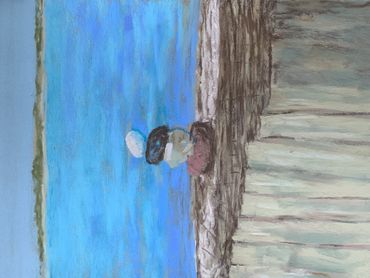A serene beach scene with balanced stones on a wooden fence overlooking the ocean.
