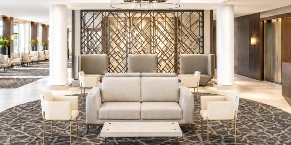 Modern hotel lobby with elegant seating and decorative panel.