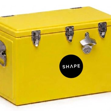 Yellow metal cooler with bottle opener and black SHAPE logo.