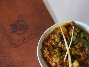 A bowl of Aloo Baigan on a menu