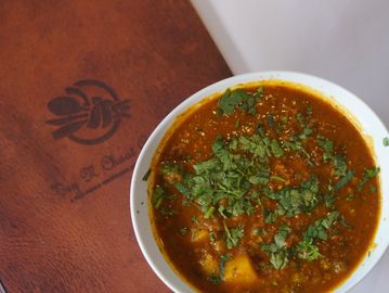 A bowl of Aloo Matter on a menu