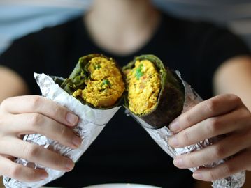 Two Paneer Bhurji Wraps on both hands