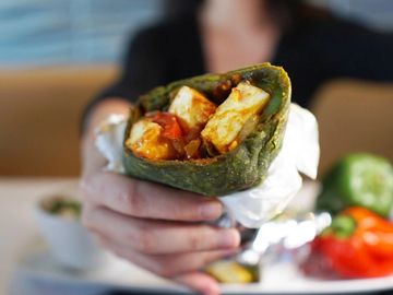 A hand holding a Chilli Paneer Wrap