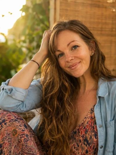 Smiling young woman with long hair in relaxed setting.