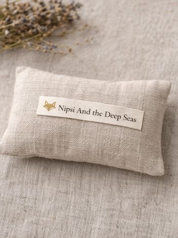 Small beige pillow with text label.
