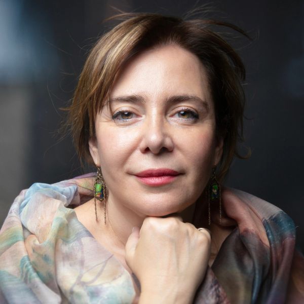 Close-up portrait of a woman with colorful scarf and dangling earrings.