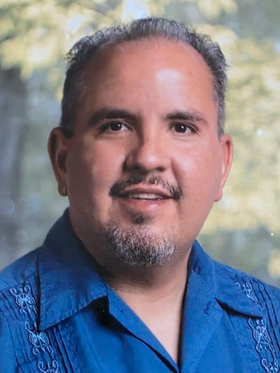 Smiling man with short hair and facial hair.