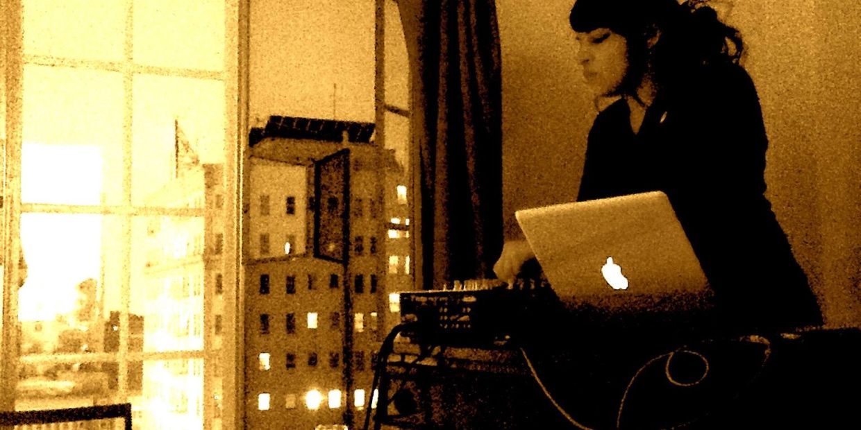 Person using a laptop near a window at night.