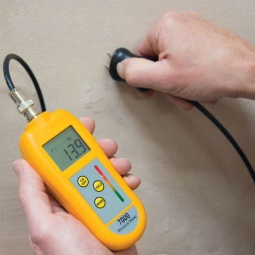Moisture meter testing water damage levels inside wall. Moisture meter testing water damage levels inside wall.